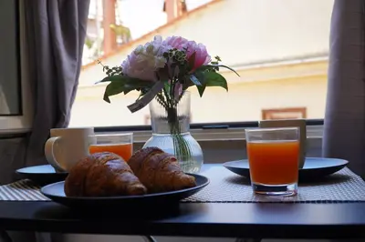 a table with plates of food and a vase of flowers and drinks at 200 mt Quattro Canti- Appartamento Rovere in Palermo