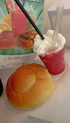 a table with two drinks and a sandwich and a bagel at La Casetta di Isola in Isola delle Femmine