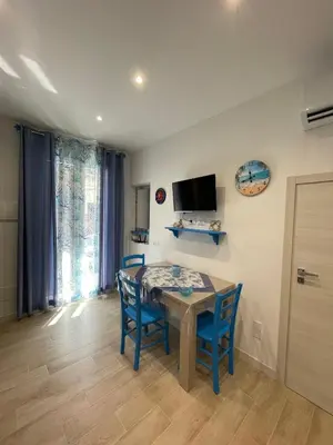 a dining room with a table and chairs and a tv at La Casetta di Isola in Isola delle Femmine
