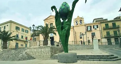 a green statue in front of a building at La Dolce Vita in Campofelice di Roccella