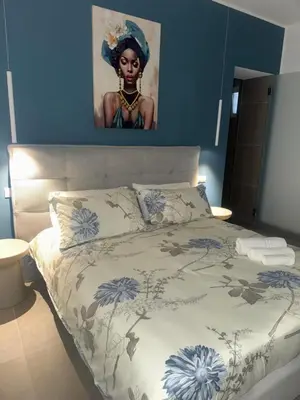 a bedroom with a bed with a painting on the wall at Luxury Rooms Soraja in Palermo