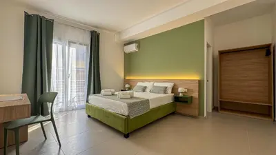 a bedroom with a bed and a large window at Tevergad Premium Rooms in Terrasini