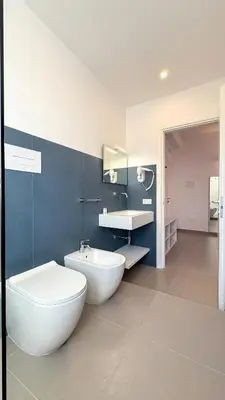 a bathroom with a white toilet and a sink at Tevergad Premium Rooms in Terrasini