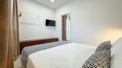 a white bedroom with a bed and a window at Tevergad Premium Rooms in Terrasini