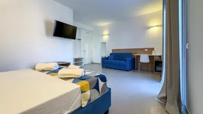 a hotel room with a bed and a blue couch at Tevergad Premium Rooms in Terrasini