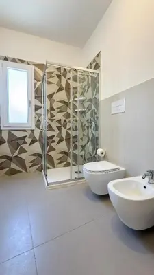 a bathroom with a shower and a toilet and a sink at Tevergad Premium Rooms in Terrasini