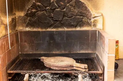 a brick oven with a pie on top of it at Villa Carmen in Mandra Capreria