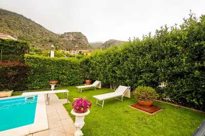 a backyard with a swimming pool and a lawn with chairs at Villa Carmen in Mandra Capreria