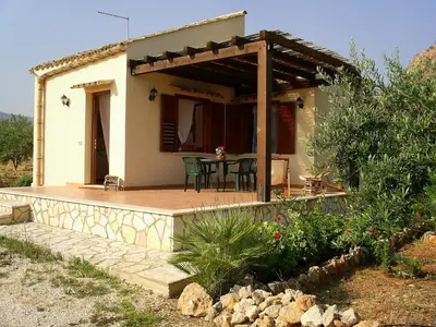 a small house with a patio with a table at Villa Chiara in Scopello