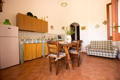 a kitchen with a table and chairs and a refrigerator at Villa Chiara in Scopello