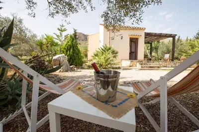 a bottle of wine sitting on a table in a yard at Villa Chiara in Scopello