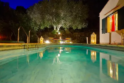 a large swimming pool at night with a house at Villa Rosa Dei Venti - Scopello-Villas in Scopello