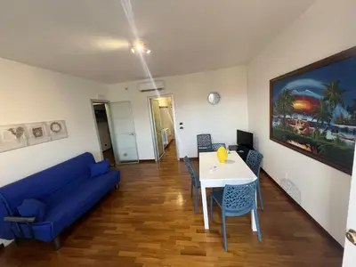 a living room with a blue couch and a table at Mondello Tolomea guest house in Mondello