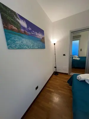 a bedroom with a bed and a painting on the wall at Mondello Tolomea guest house in Mondello