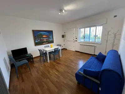 a living room with a blue couch and a table at Mondello Tolomea guest house in Mondello