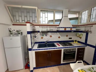 a small kitchen with a sink and a refrigerator at Mondello Tolomea guest house in Mondello
