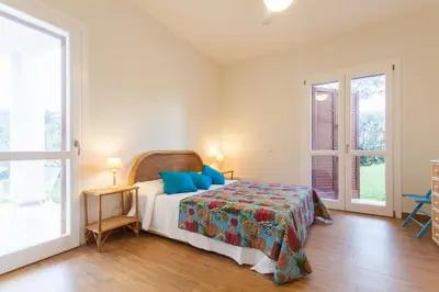 a bedroom with a bed with blue pillows on it at Villa dell'Ulivo - by DomuSicily in Terrasini