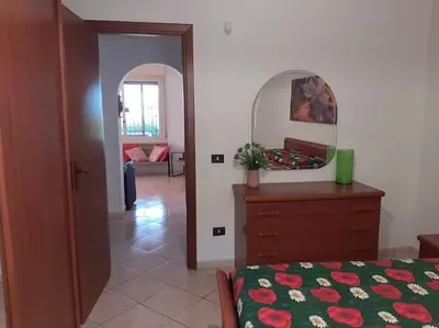 a bedroom with a bed and a dresser with a mirror at Casa Vacanze Anthea Carini in Carini