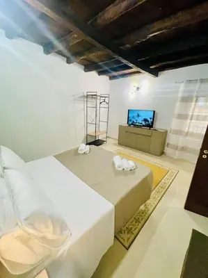 a bedroom with a bed and a flat screen tv at Biscottari's home in Palermo