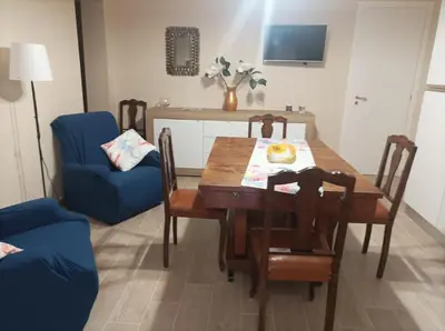 a dining room with a wooden table and blue chairs at Casa Nenè in Trabia