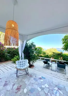 a patio with a white chair and a chandelier at Rosa's House in Santa Flavia