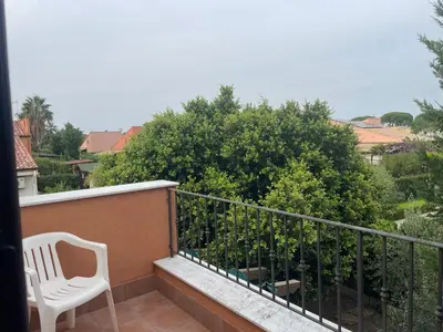 a white chair sitting on a balcony at Villetta 200mt mare e piscina in Campofelice di Roccella