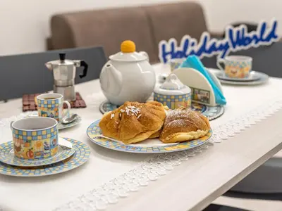 a table with plates of pastries and cups on it at La Casetta di Mari by Holiday World in Villabate