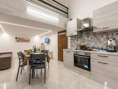 a kitchen and dining room with a table and chairs at La Casetta di Mari by Holiday World in Villabate