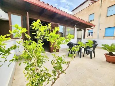 a patio with two tables and chairs and plants at Bay View Wi-Fi-Vista Mare-Free Parking in Carini