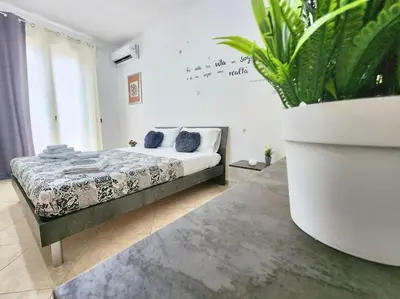 a bedroom with a bed and a large potted plant at Bay View Wi-Fi-Vista Mare-Free Parking in Carini