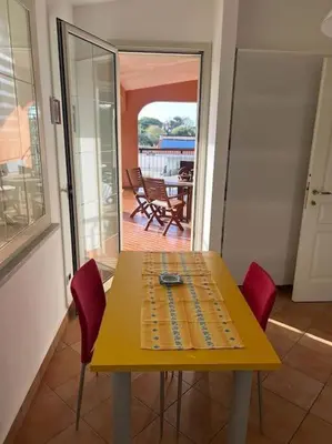 a yellow table with red chairs in a room at traversa 8, aeroporto in Cinisi
