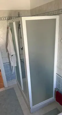 a bathroom with a shower and a glass door at traversa 8, aeroporto in Cinisi