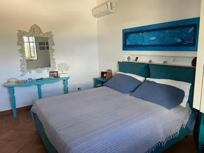 a bedroom with a blue bed and two blue tables at traversa 8, aeroporto in Cinisi