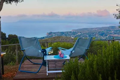 two blue chairs sitting on a deck with a table at Villa Conchiglia - Scopello-Villas in Scopello
