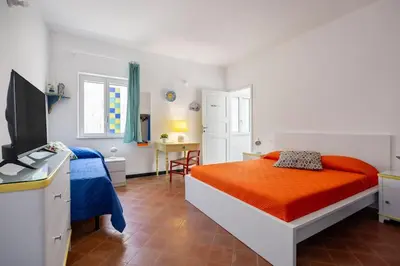 a bedroom with a bed and a desk with a television at Terrazza sul mare in Santa Flavia