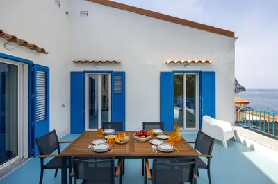 a dining room with a table and chairs and the ocean at Terrazza sul mare in Santa Flavia