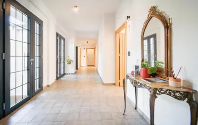 an empty hallway with a mirror and a table at Dimora Harmonia in Carini