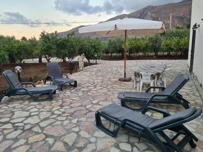 a group of chairs and an umbrella on a patio at Casa il Sole Casevacanze Ferienwohnung Daniele Furco in Castellammare del Golfo
