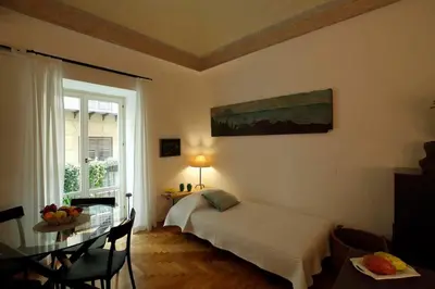 a bedroom with a bed and a table and a window at Porto Felice Home Palermo in Palermo