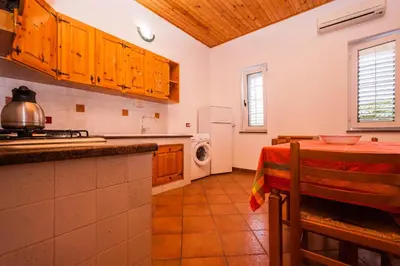 a kitchen with a table and a microwave at Villa Cicas sul mare in Campofelice di Roccella
