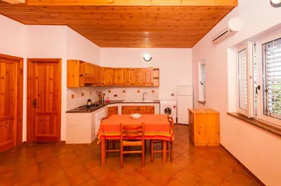 a kitchen with a table and chairs in a room at Villa Cicas sul mare in Campofelice di Roccella