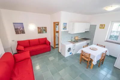 a living room with a red couch and a table at Villa Cicas sul mare in Campofelice di Roccella