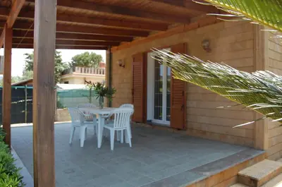 a patio with a table and chairs on a porch at Villa Cicas sul mare in Campofelice di Roccella