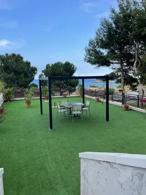 a gazebo with a table and chairs on a lawn at La Terrazza del Sole in Lido di Mondello
