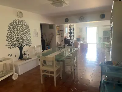 a living room with a table and chairs at La Terrazza del Sole in Lido di Mondello