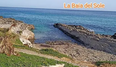 a view of the ocean with a rocky coastline at La Terrazza del Sole in Lido di Mondello
