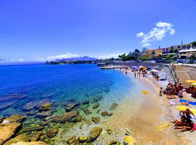 a group of people on a beach near the water at Seafront House Gabbiano Blu in Santa Flavia