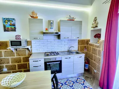 a kitchen with a sink and a stove top oven at Seafront House Gabbiano Blu in Santa Flavia