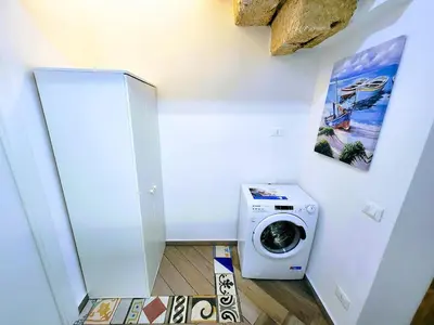 a washer and dryer in a room with a wall at Seafront House Gabbiano Blu in Santa Flavia