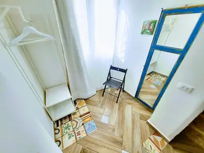 a room with a mirror and a chair in it at Seafront House Gabbiano Blu in Santa Flavia